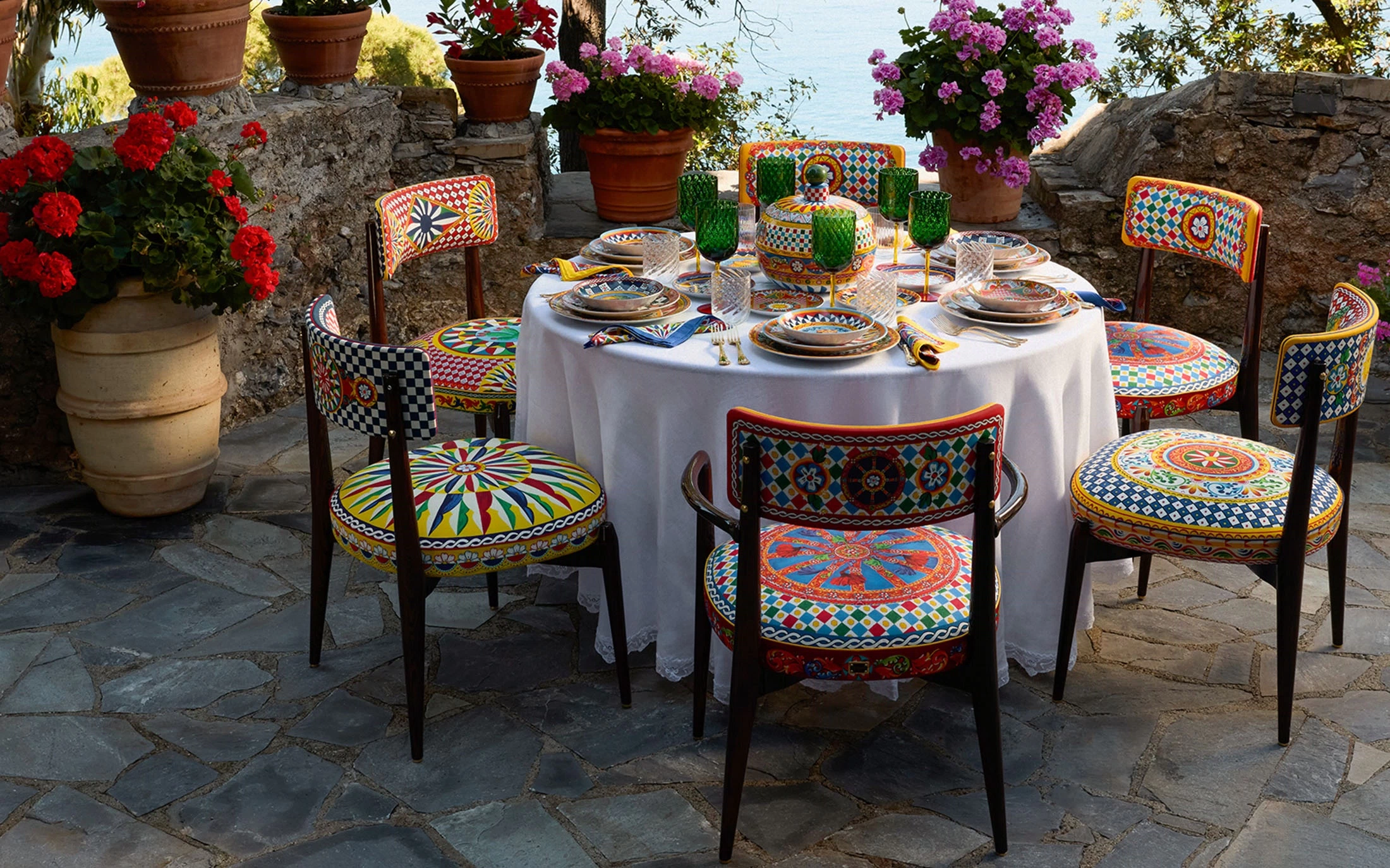 A Sicilian terrace table set with hand-painted ceramics above the sea